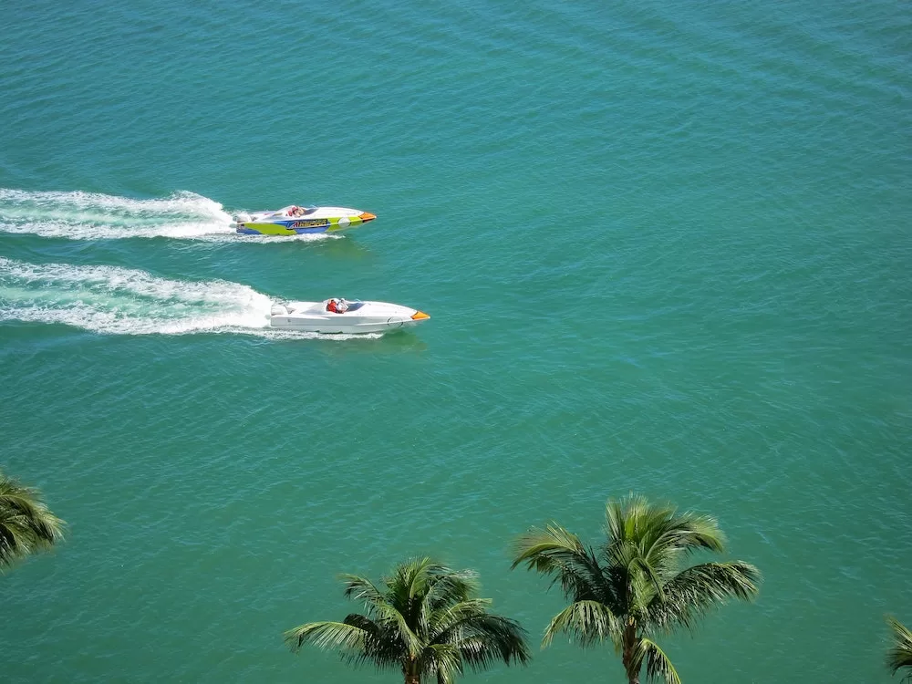 Boats in a race competition across blue water.