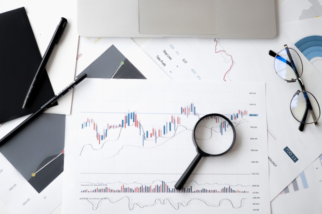 Magnifying glass  and eyeglasses on a pile of charts, to symbolize learning from last year.