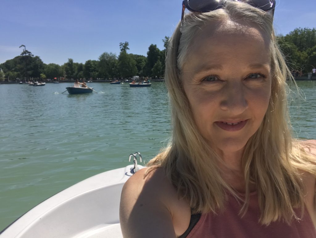 Anchor Virtual Assistants owner Karen Zachary in a white rowboat on a blue lake.